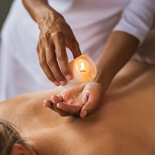 closeup-of-masseuse-hands-pouring-wax-from-a-candl-2025-10-10-22-08-21-utc
